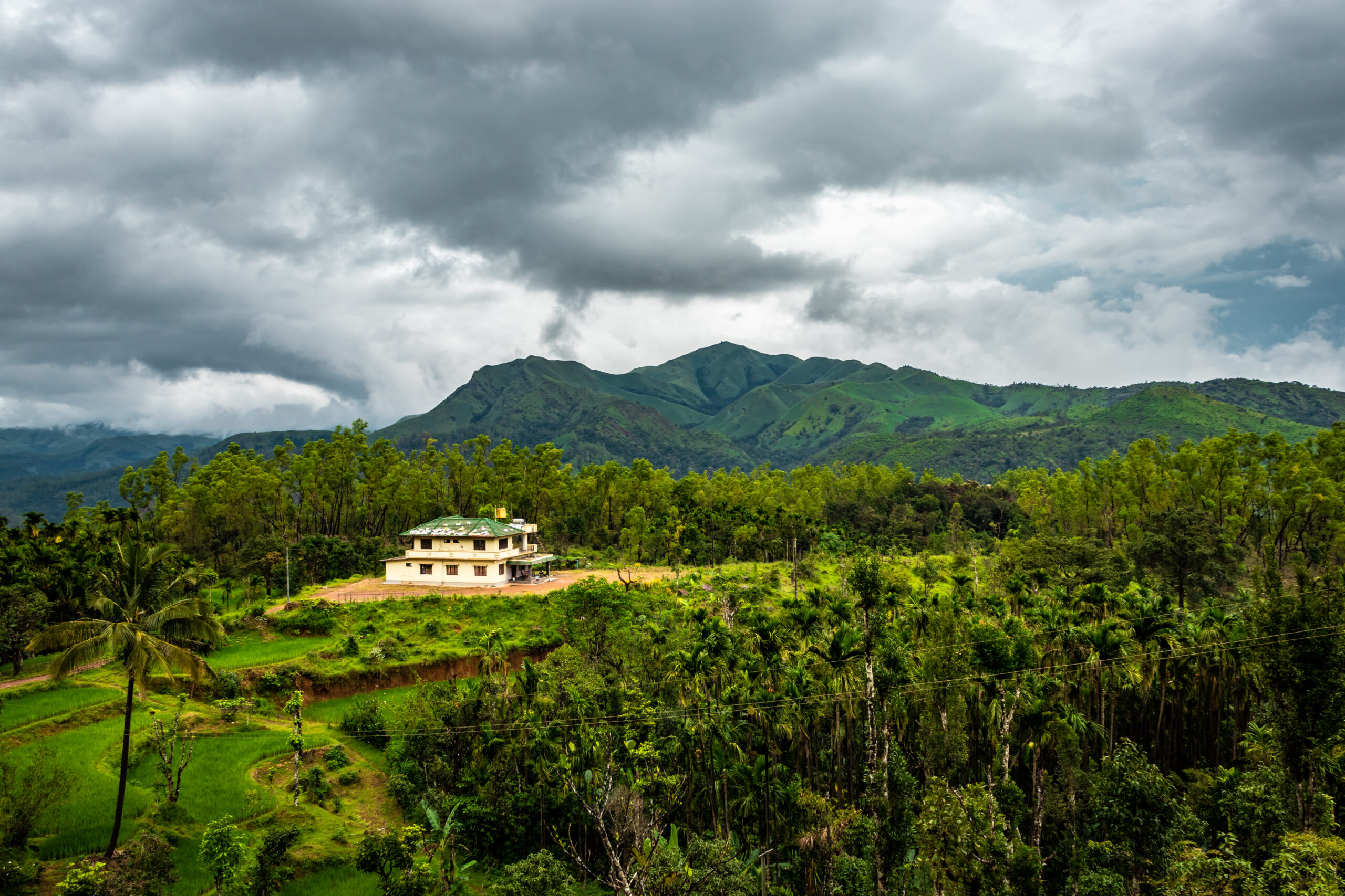 house at coorg village isolated with mountain coverd clouds and green forests